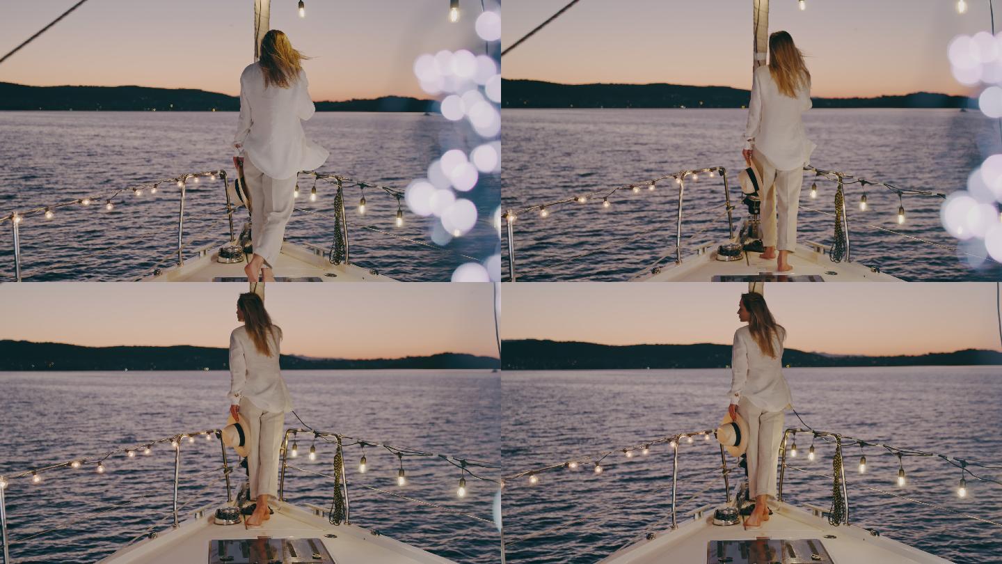 斯洛莫年轻女子在日落时分从帆船甲板欣赏风景