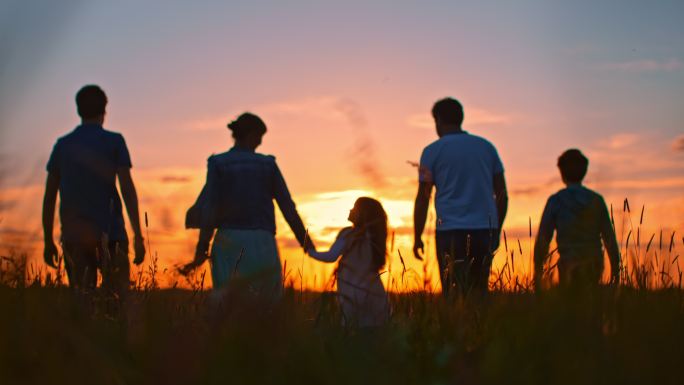 日落时分，斯洛莫一家带着三个孩子在草地上散步