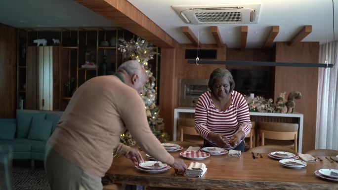 老年夫妇在家摆好餐桌准备圣诞晚餐或午餐