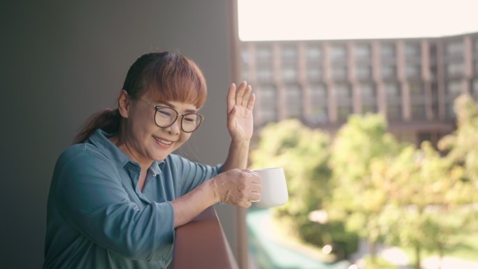 一天早上，在公寓里，快乐的女人向邻居挥手致意