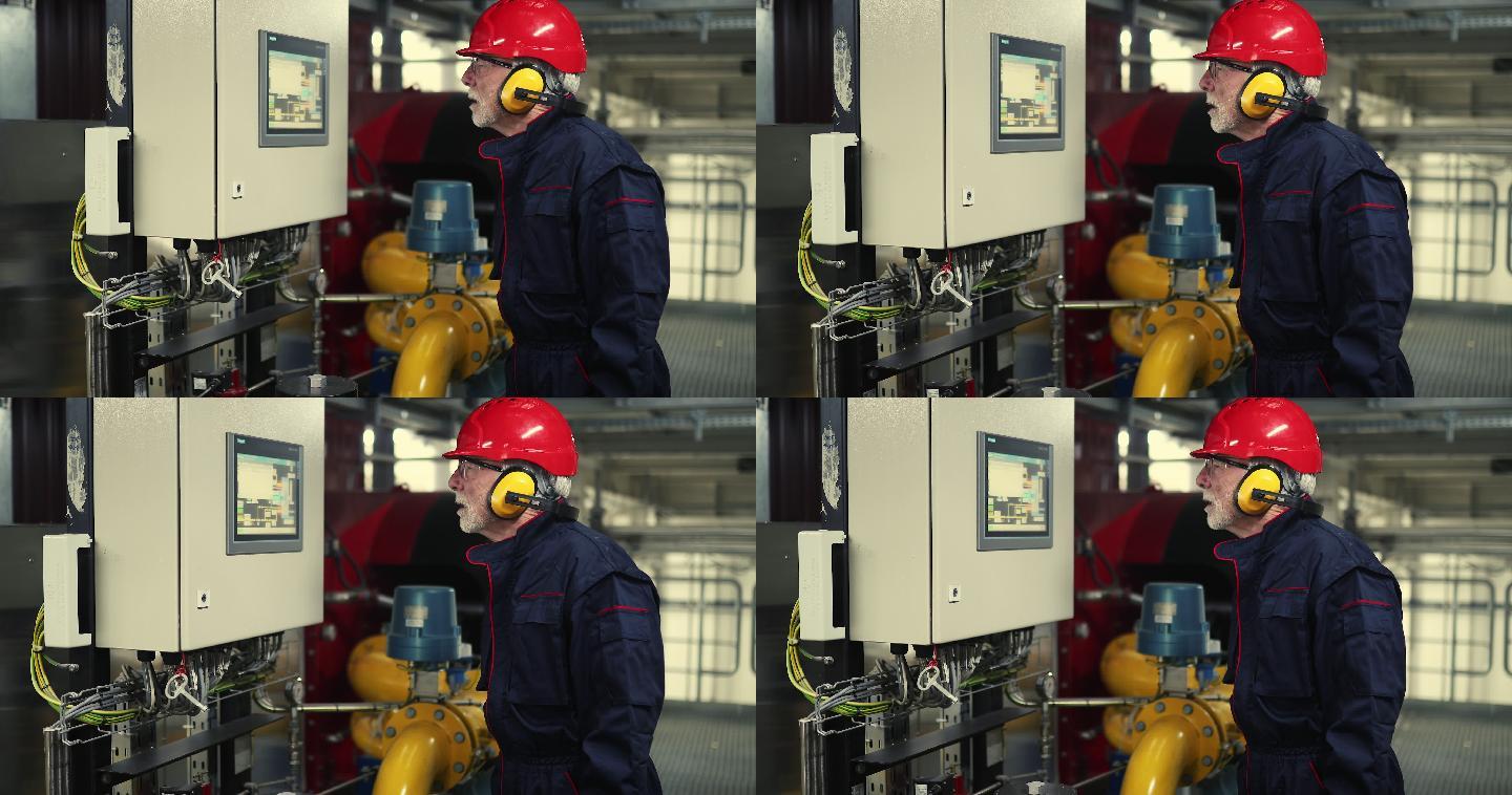 一位男性高级工程师在加热厂为机器编程。