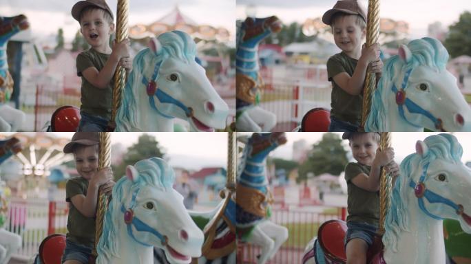 可爱的小男孩在游乐园玩旋转木马