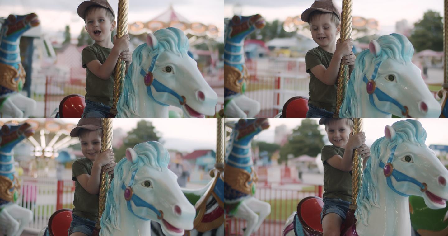 可爱的小男孩在游乐园玩旋转木马