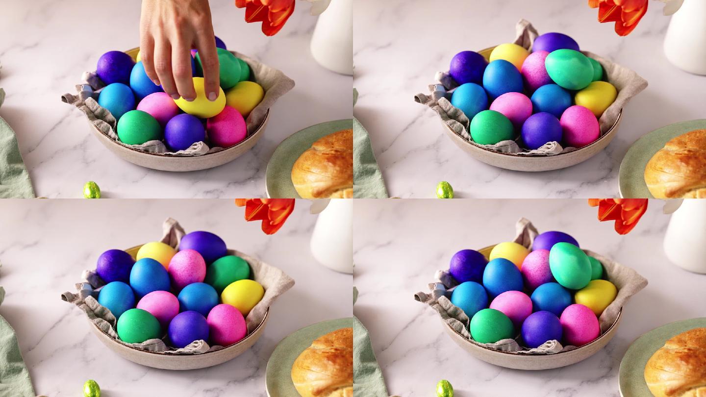 一位女士在桌子上方的碗中摆放五彩复活节彩蛋