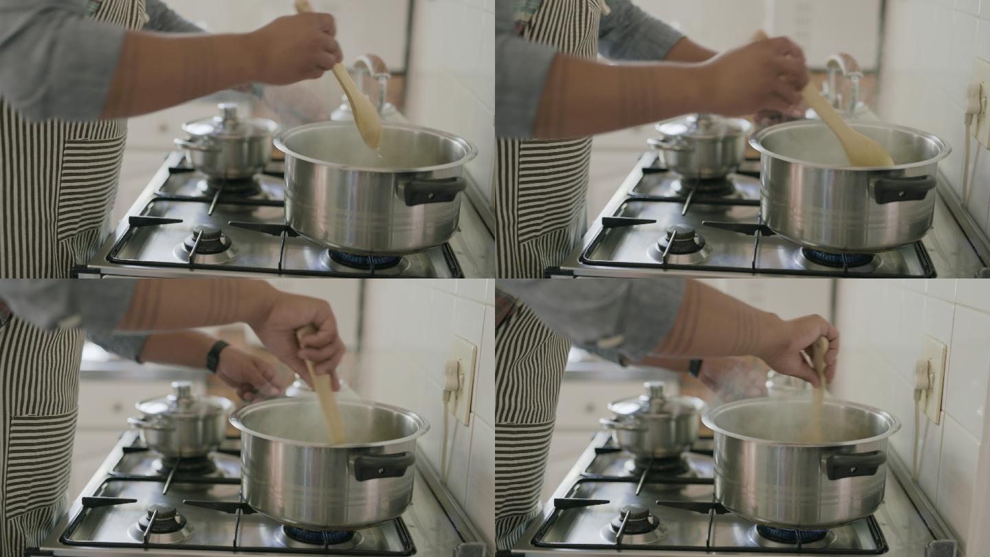 一个面目全非的男子在家做饭时在煤气炉上搅拌锅子的4k视频片段