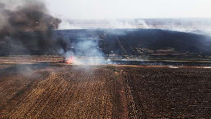 农田燃烧的火焰鸟瞰图，了解土壤肥力。