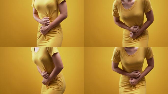 一名女性胃痛，背景为黄色