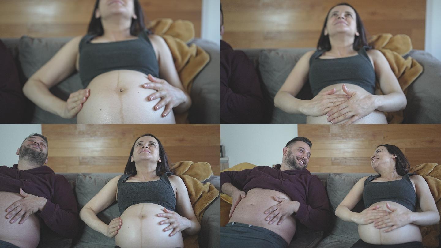 面带微笑的丈夫赤裸着肚子出来揉着肚子，爱着支持怀孕的妻子