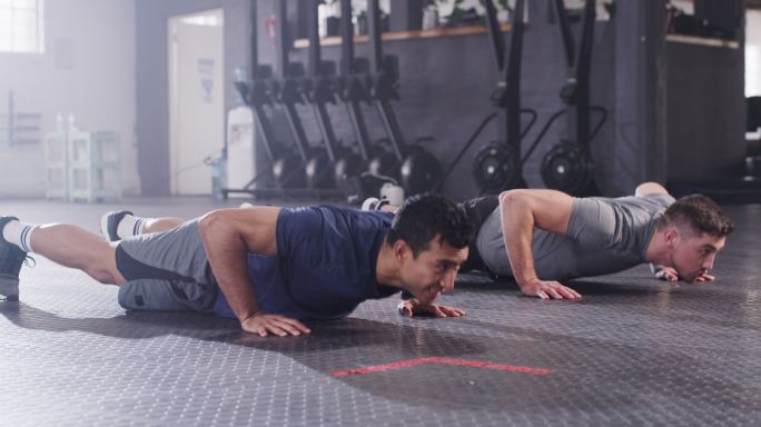 两名男子在健身房做俯卧撑，分享击掌的4k视频片段
