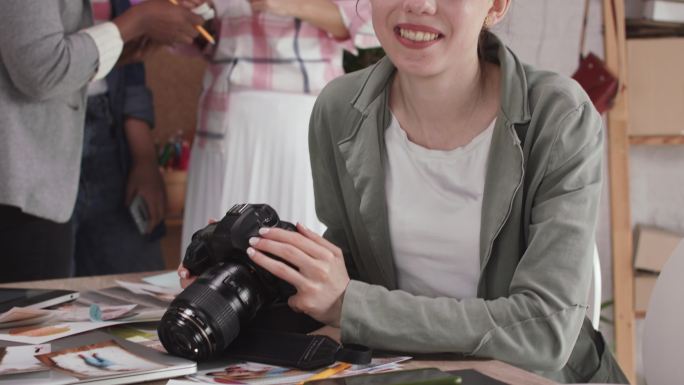 年轻女摄影师手持数码相机，思考新项目