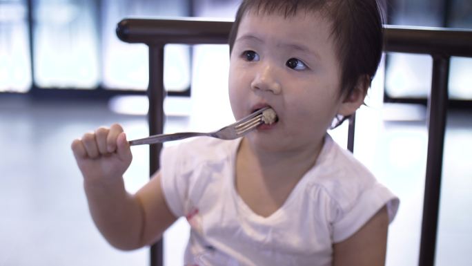 亚洲小女孩早餐吃香肠