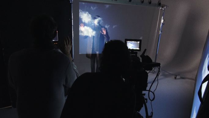 工作室拍摄了摄影师戴着虚拟现实模拟眼镜拍摄商人的场景