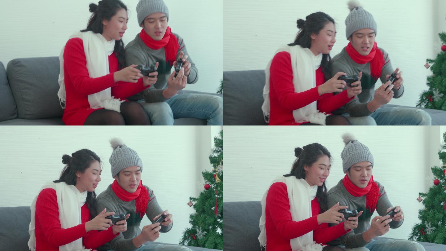 亚洲年轻夫妇在家一起玩游戏，按下游戏手柄按钮