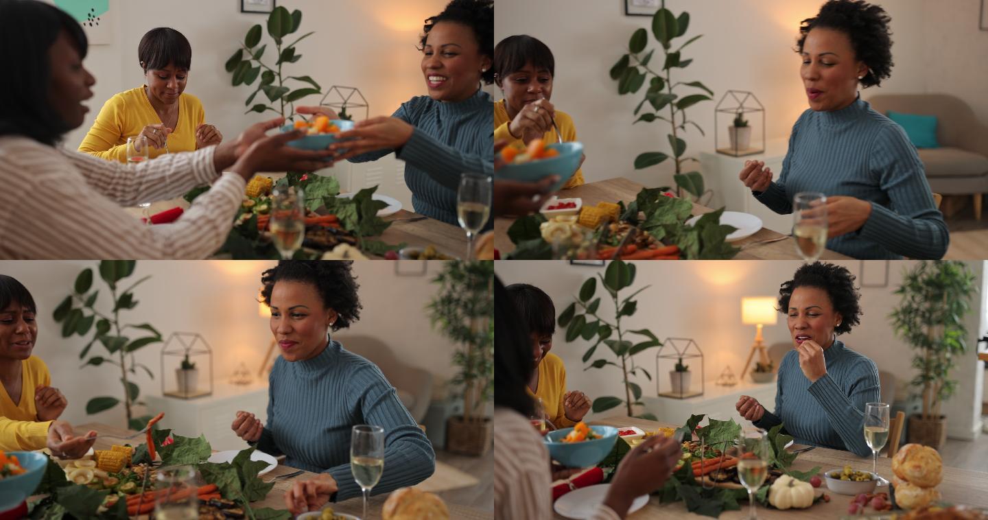 三位女性朋友在家吃素食午餐时分享食物