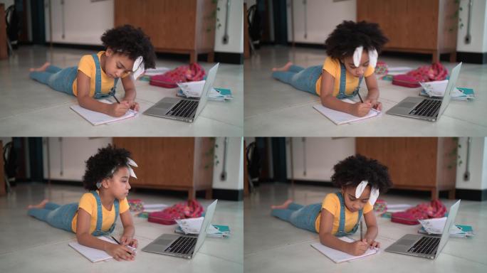 Elemantary age女孩躺在家里的地板上学习看在线课程