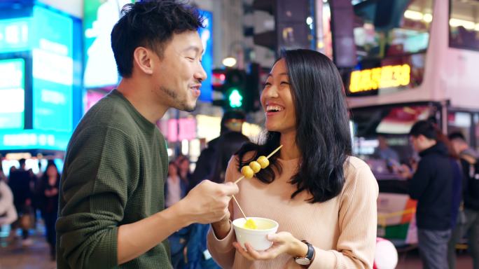 斯洛·莫（SLO MO）手持式中景，一对年轻夫妇在香港吃街头小吃