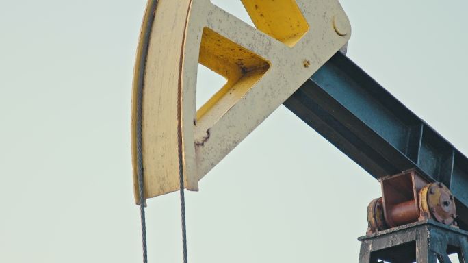 燃油和发电系统油井抽油机。日落时分，石油发电站油田钻机作业的特写镜头。