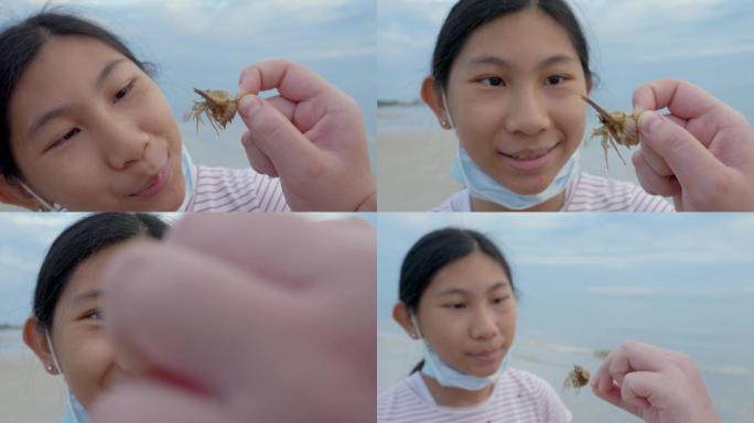 日出时分，一个戴着面具的亚洲男孩在海滩上用手抓寄居蟹。男孩告诉他的妹妹关于寄居蟹的生活理念。