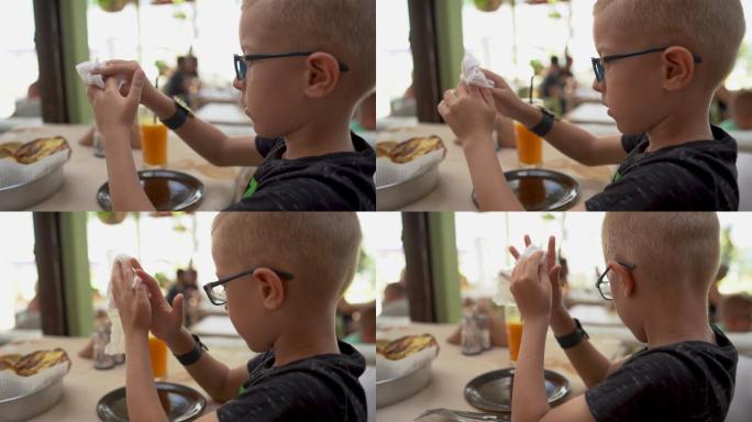 餐馆里的一个男孩饭前用湿纸巾擦手