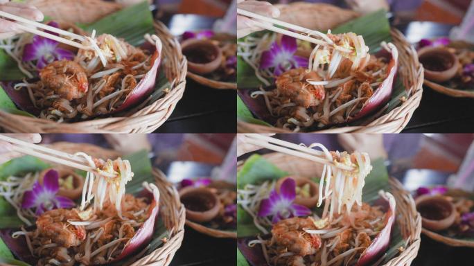 在盘子上用筷子吃虾垫泰式面条，在一张古老的绿松石木板桌上放香蕉叶，面条是用新鲜的水蒸汽加热制成的
