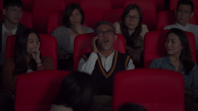 坏习惯粗鲁的亚裔中国老人在电影放映期间，在黑暗中大声讲电话，打扰和忽视周围的其他观众。一个女孩用手指