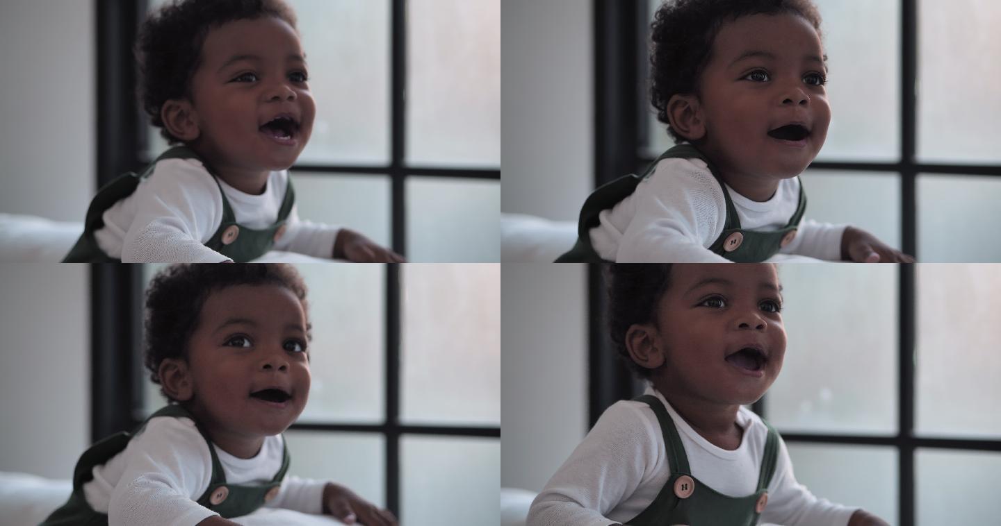 欢快的非洲民族肖像，幼儿年龄5个月，欢笑着享受在家玩耍的自由时光。儿童生活中的一天概念。
