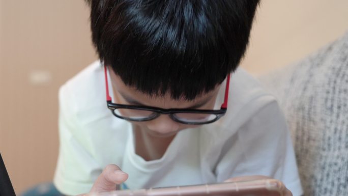 亚洲男孩玩智能手机。