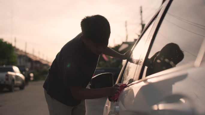 日落时分亚洲男子在家洗车