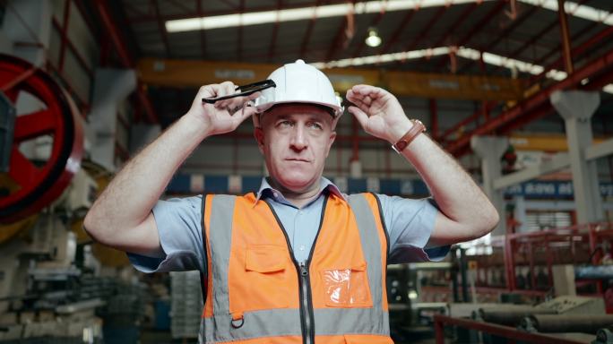 高级工业工程师或技术员熟练，准备在生产线工作，穿戴个人防护装备、安全帽、安全眼镜，在重型制造厂工作。