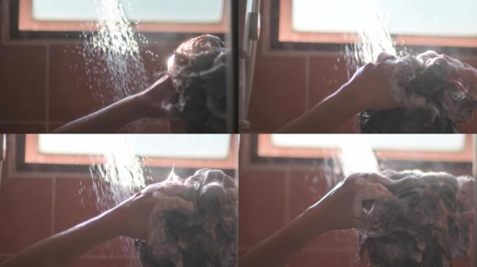 慢镜头晨曦背光浴室亚裔中国女性用自来水洗头