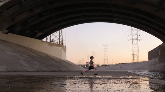 在桥下锻炼的女人生活方式女子压腿全身健身
