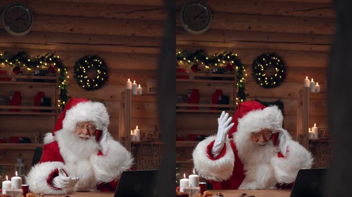 圣诞老人正坐在办公室的一张桌子旁，用他的红色智能手机进行情感对话