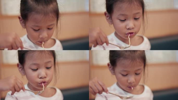 亚洲小女孩在餐厅吃日本面条的特写镜头