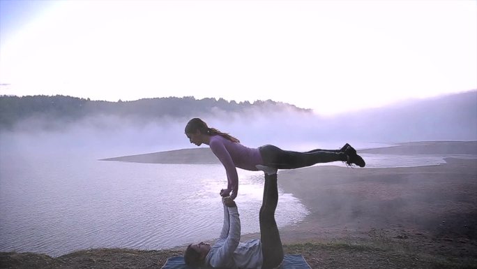 两位年轻美丽的女性正在做瑜伽——高空飞行的鲸鱼做瑜伽姿势。