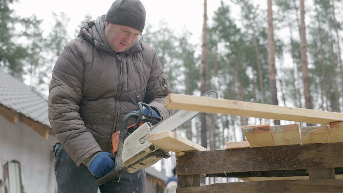 木匠用电锯锯切松板。