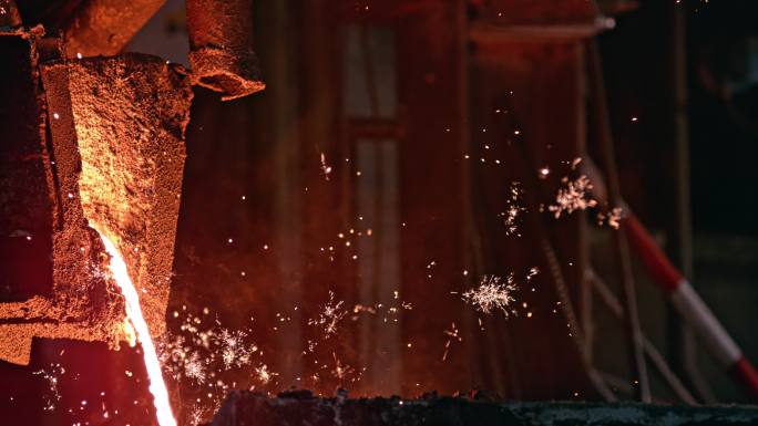 熔化的金属倒入钢厂时，火花四溅