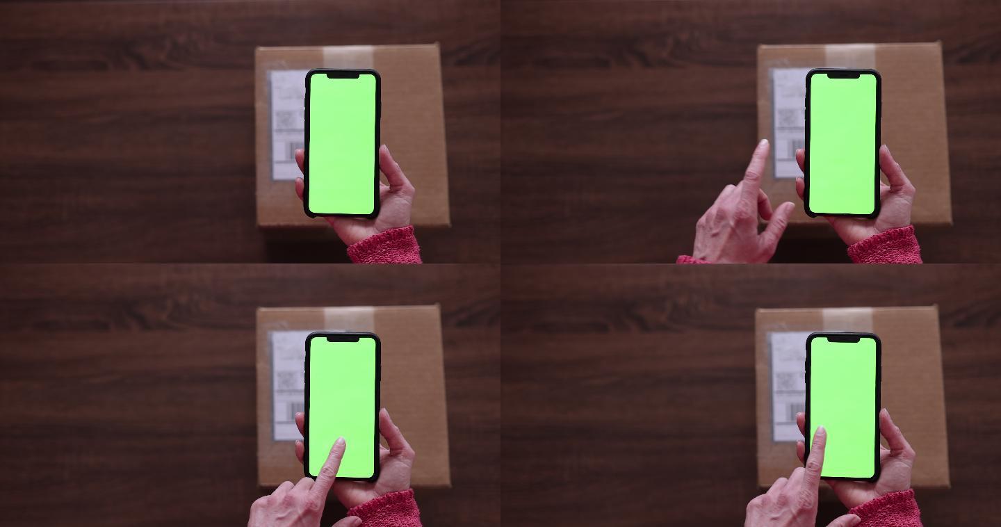 女性手持chroma键绿色屏幕手机扫描标签并退回包裹的特写镜头