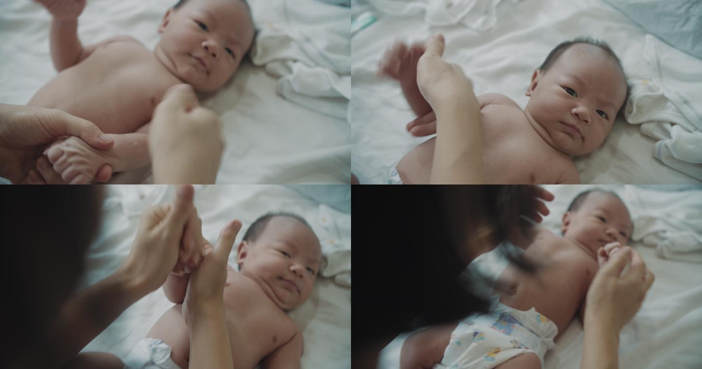 亚洲母亲在男婴身上涂抹润肤霜（0-1个月）