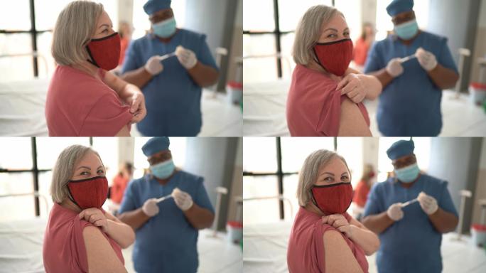 一位年长女性在接种疫苗前展示手臂的肖像-戴着口罩