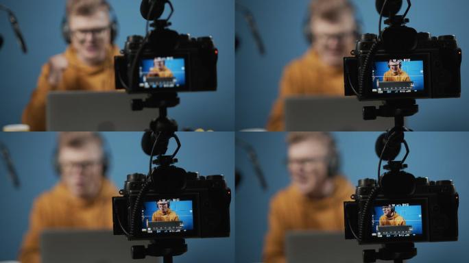 一个年轻金发博主的后台视频，在工作室录制，焦点放在摄像机屏幕上