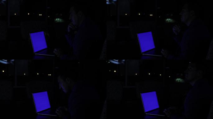在停电期间，一位成年商人兼办公室工作人员在一个风雨交加的夜晚用笔记本电脑拍摄4K视频系列