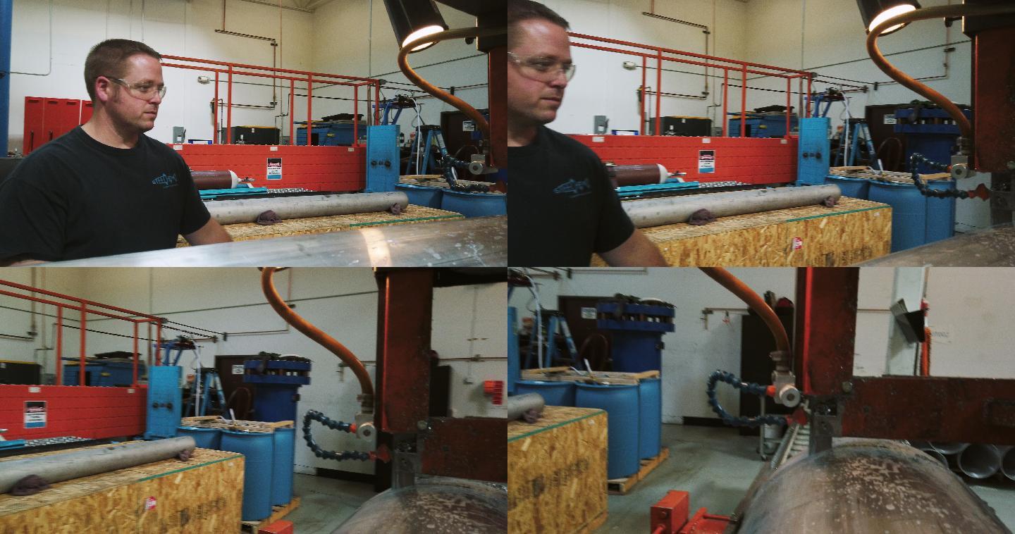 一名30多岁的高加索技术人员在室内制造厂使用大型工业带锯切断旋转成型的钢桶