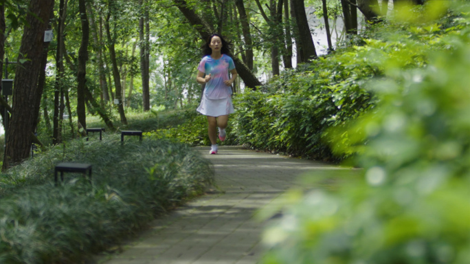美女清晨森林公园跑步树林林荫道跑步视频