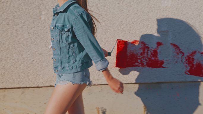 斯洛·莫（SLO MO）用红色颜料画墙走在城市街道上独立女艺术家用城市涂鸦艺术欣赏艺术表现