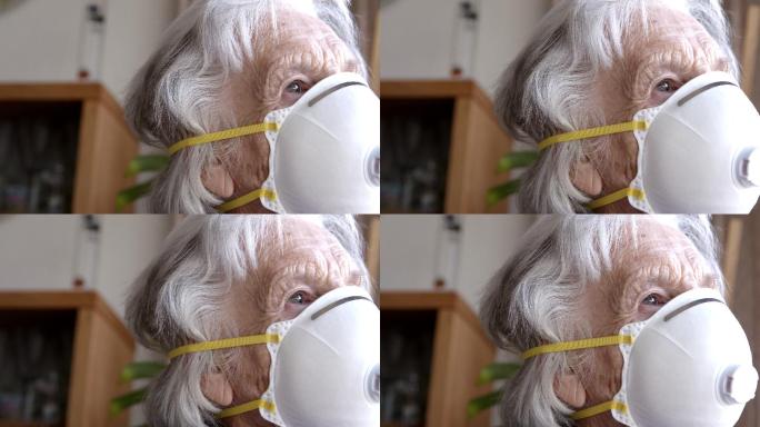 特写镜头：心烦意乱的高加索人老年妇女戴着n95防护口罩看着窗外，感到孤独，以防止新冠病毒SARS n