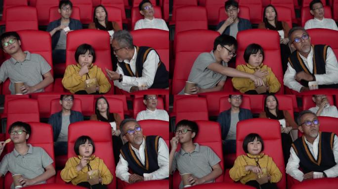 亚裔中国爷爷和孙子喜欢在电影院看电影。