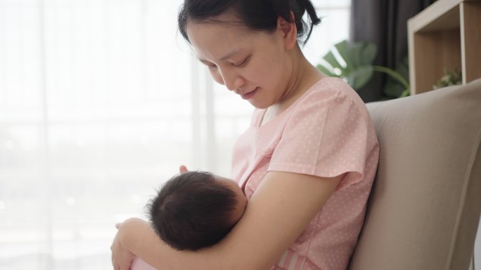 亚洲年轻母亲母乳喂养婴儿。