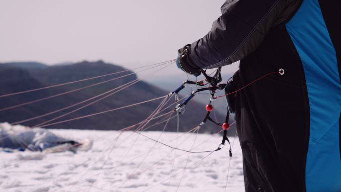 在阳光明媚的冬日进行滑翔伞飞行，鸟瞰图。极限运动和冒险越野飞行员。