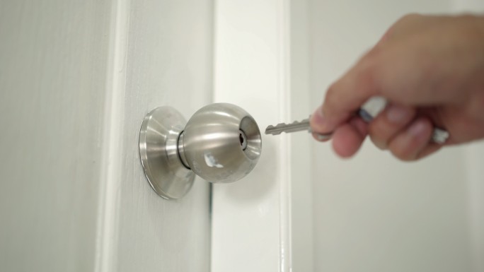 男人的手用钥匙开锁，家里的门