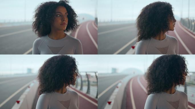 一位身穿白色紧身衬衫、留着黑色卷发的迷人年轻女子站在桥上四处张望